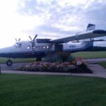 Twin-engine skydive jump plane parked on the ramp with the cabin door open at a skydiving drop zone