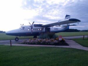 Twin-engine skydive jump plane parked on the ramp with the cabin door open at a skydiving drop zone