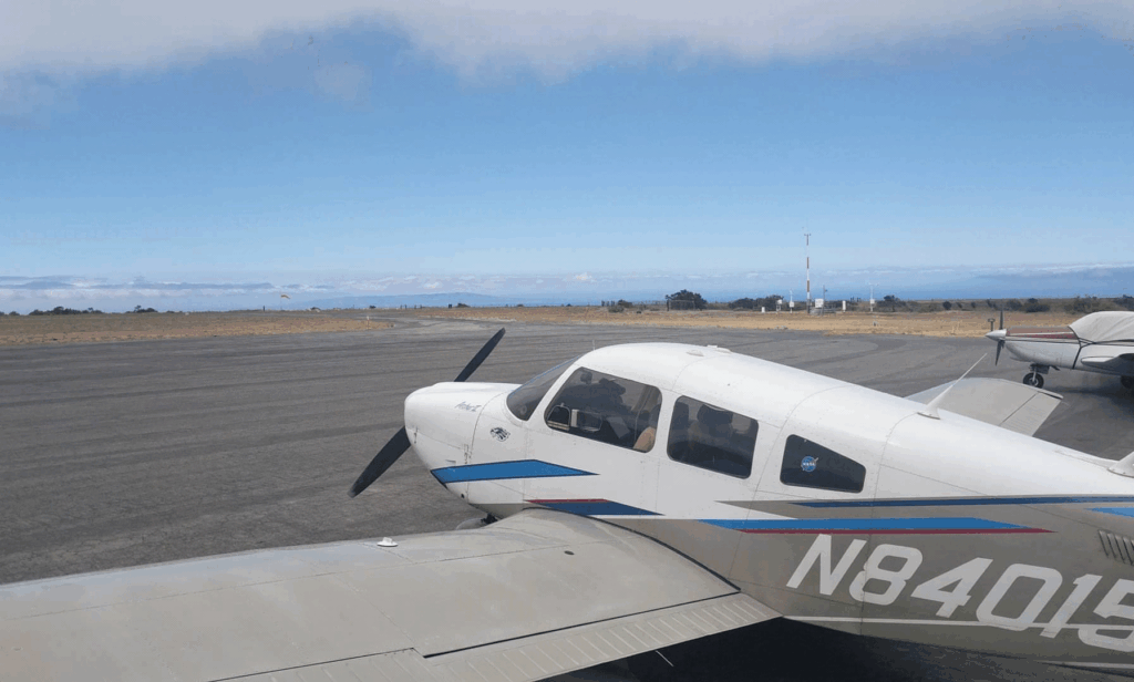 A Piper Archer II parked on the ramp with coastal clouds in the background, part of The Flight Academy’s training fleet.