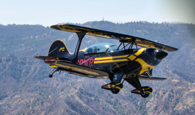A Pitts aerobatic biplane flying over the valley hills near Van Nuys during an aerobatics training flight.